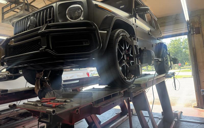 Black Mercedes G-Wagon on the alignment rack with alignment sensors on the wheels